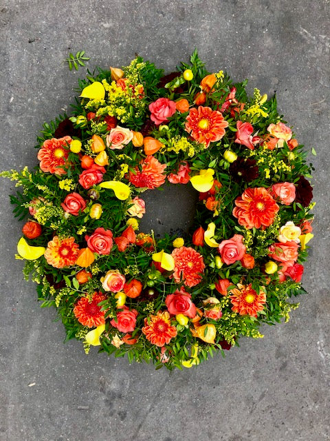 Couronne de deuil de fleurs fraiches dans les tons orange et jaune